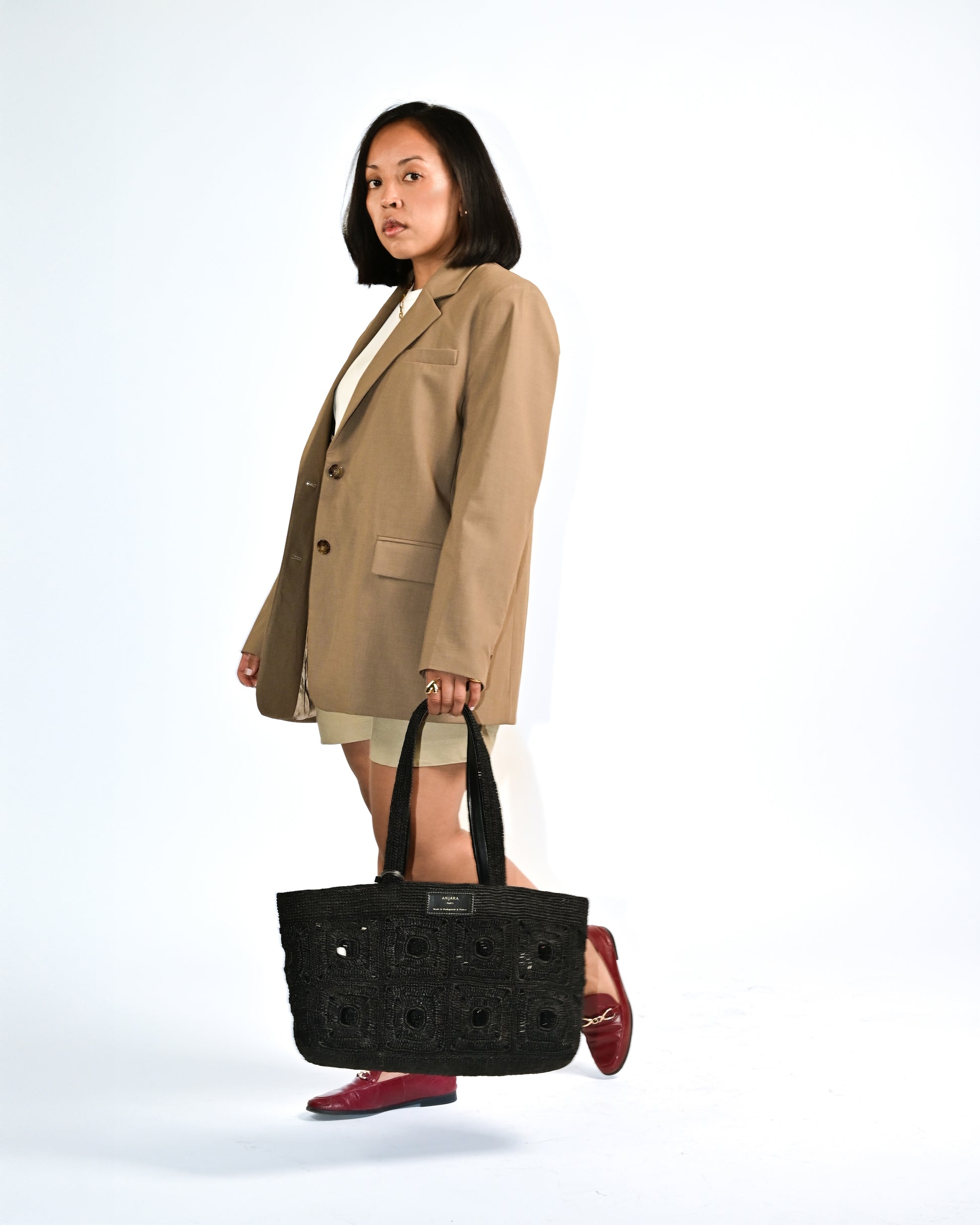 Cabas en raphia noir Anjara porté main Détails haut de gamme et finitions Uppeal noir alternative au cuir, sac à main vegan intemporel moderne et durable