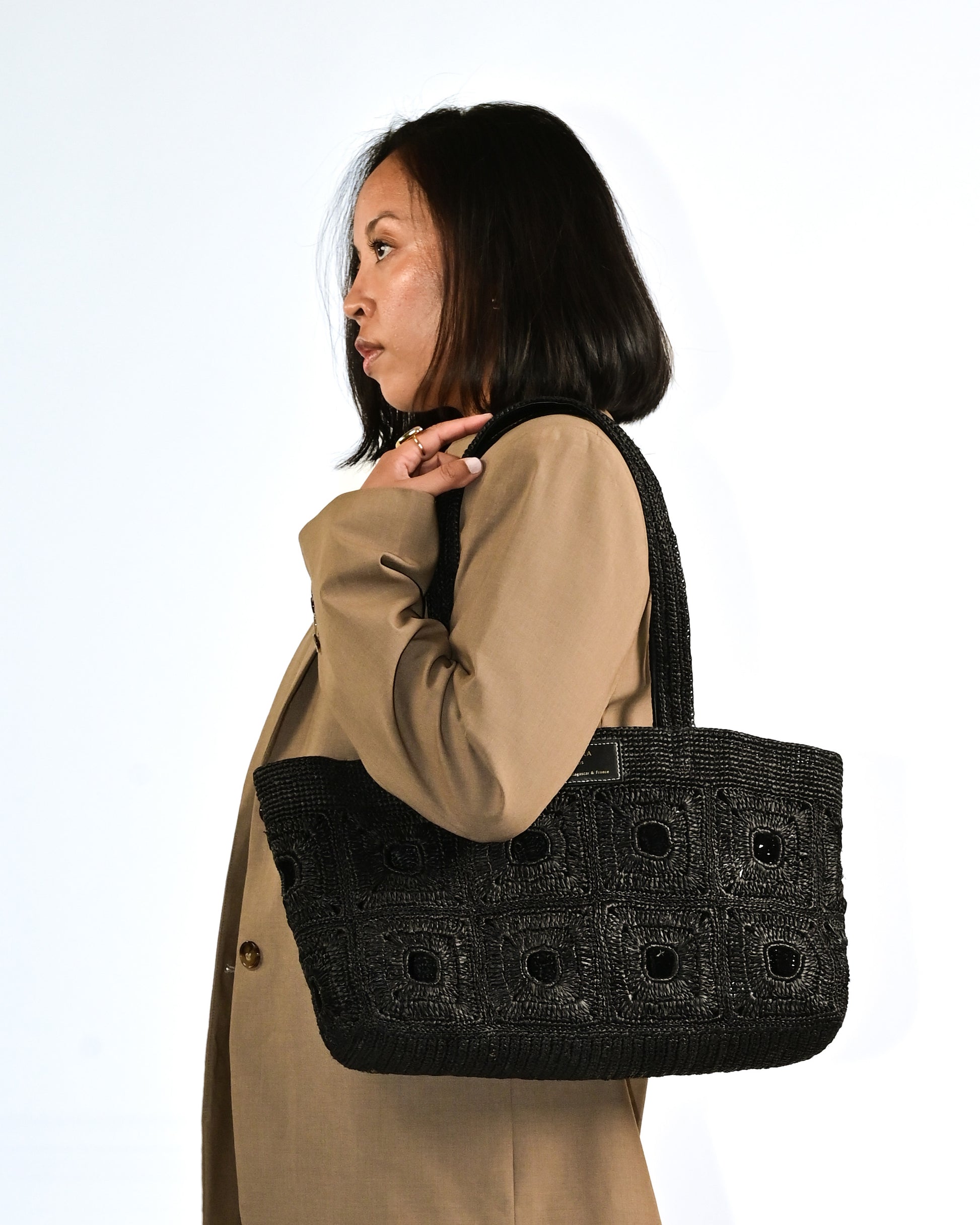 Cabas en raphia noir Anjara porté épaule. Détails haut de gamme et finitions Uppeal noir alternative au cuir, sac à main vegan intemporel original et durable